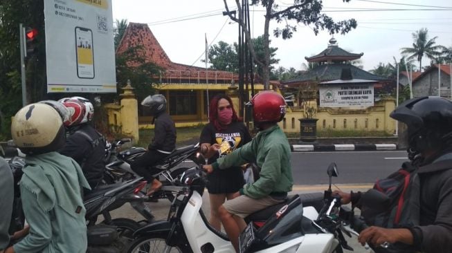 Waria Kulon Progo (Warkop) bagi-bagi masker gratis di pemberhentian lampu APILL depan Terminal Wates, Kulon Progo, Sabtu (18/4/2020). - (SuaraJogja.id/Hiskia Andika)