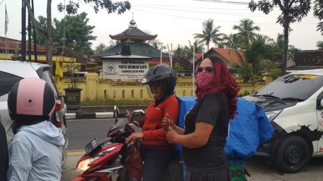 Waria Kulon Progo (Warkop) bagi-bagi masker gratis di pemberhentian lampu APILL depan Terminal Wates, Kulon Progo, Sabtu (18/4/2020). - (SuaraJogja.id/Hiskia Andika)