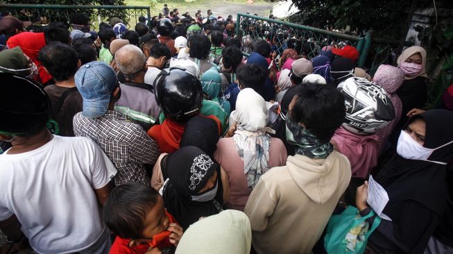 Warga antre sembako tanpa jaga jarak di gedung Baznas Kabupaten Bogor, Cibinong, Bogor, Jawa Barat, Senin (20/4). [ANTARA FOTO/Yulius Satria Wijaya]
