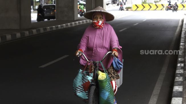 Pedagang membawa barang dagangannya dengan sepeda melintas di kawasan Kebayoran Baru, Jakarta, Selasa (21/4). [Suara.com/Angga Budhiyanto]











