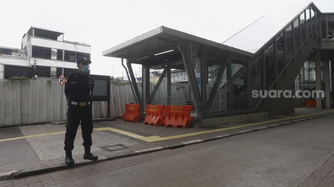 Petugas berjaga di pintu masuk Stasiun MRT Blok A, Jakarta Selatan, Selasa (21/4). [Suara.com/Angga Budhiyanto]