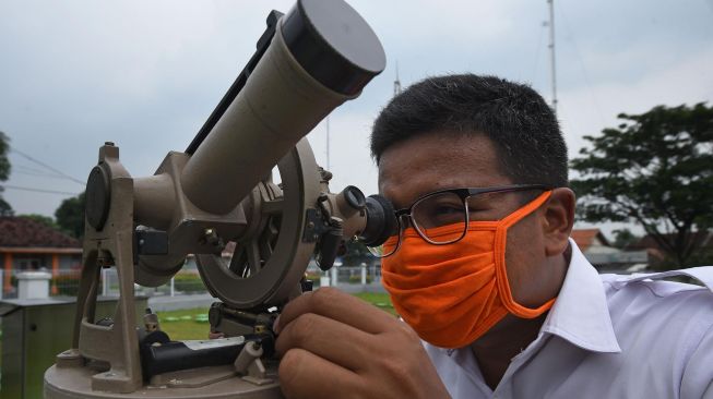 Petugas melihat teropong Theodolit untuk mengukur kecepatan dan arah angin di Laboratorium Terbuka BMKG (Badan Meteorologi Klimatologi dan Geofisika) Serang, Banten, Selasa (21/4).  [ANTARA FOTO/Asep Fathulrahman]