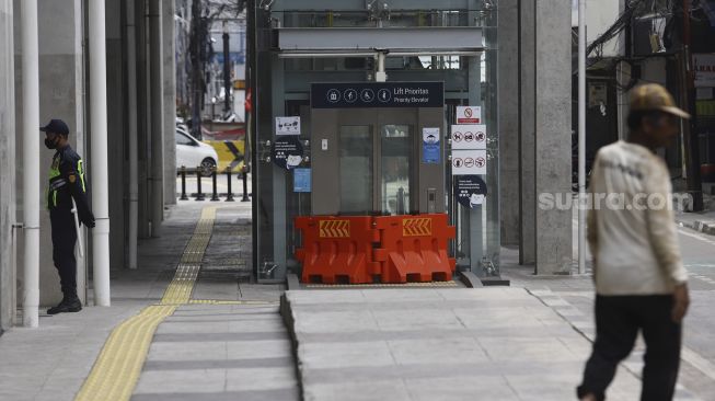 Petugas keamanan berjaga di pintu masuk Stasiun MRT Blok A, Jakarta Selatan, Selasa (21/4). [Suara.com/Angga Budhiyanto]