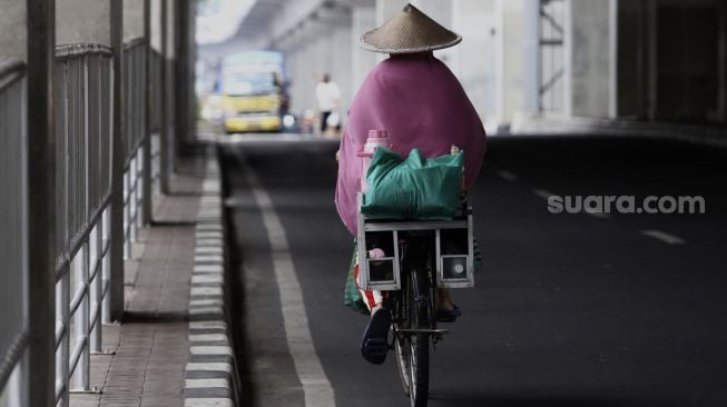 Pedagang membawa barang dagangannya dengan sepeda melintas di kawasan Kebayoran Baru, Jakarta, Selasa (21/4). [Suara.com/Angga Budhiyanto]










