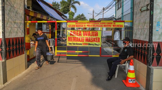 Warga Gang Pala melakukan karantina wilayah atau Lockdown mandiri di Jalan Monumen Pancasila Sakti, Lubang Buaya, Jakarta Timur (22/4). [Suara.com/Alfian Winanto]