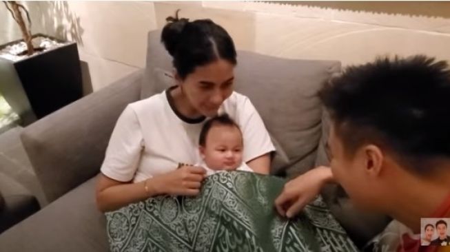 Baim Wong saat menyelimuti anaknya, Kiano Tiger Wong dengan kiswah [YouTube/Baim Paula]