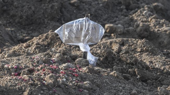 Tanda pengenal yang terbuat dari kardus berada di pusara kasus meninggal akibat virus Corona COVID-19 sebagai pengganti nisan di komplek TPU Tegal Alur, Jakarta, Rabu (22/4).  [ANTARA FOTO/Muhammad Adimaja]