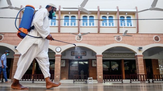 Ilustrasi sebuah masjid yang sedang disemprot cairan disinfektan.[AFP]