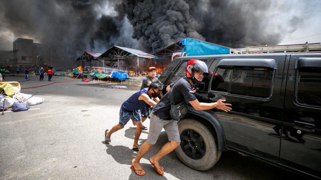 Warga berupaya menyelamatkan kendaraannya saat terjadi kebakaran di Pasar Second Taras, Batam, Kepulauan Riau, Kamis (23/4).  [ANTARA FOTO/M N Kanwa]