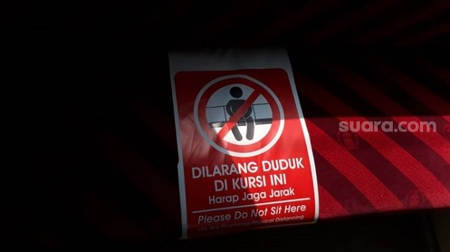 Penampakan poster imbauan jaga jarak di tempat duduk penumpang KRL. (Suara.com/Bagaskara).