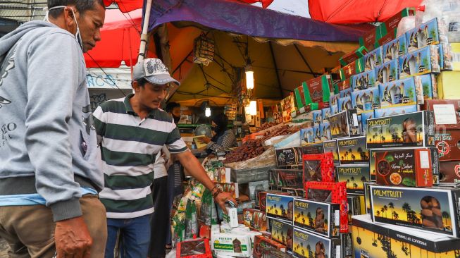 Pembeli memilih jenis kurma di Pasar Tanah Abang, Jakarta Pusat, Kamis (23/4). [Suara.com/Alfian Winanto]
