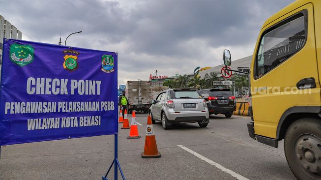 Kendaraan berhenti di check point di Bekasi, Jawa Barat, Jumat (24/4). [Suara.com/Alfian Winanto]