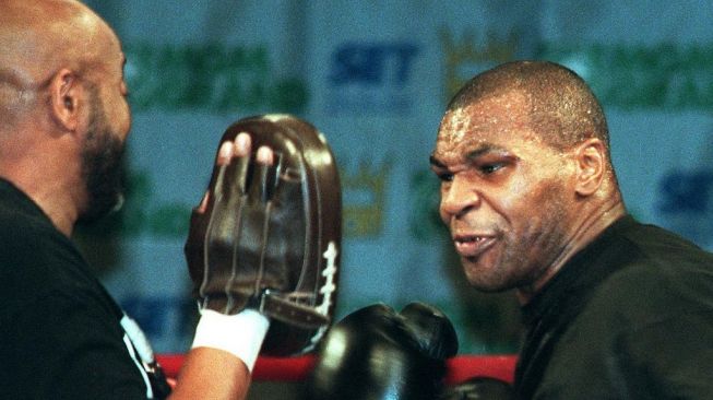 Mantan juara dunia tinju sejati kelas berat, Mike Tyson (kanan), tengah berlatih mitts dengan pelatihnya dalam persiapan menghadapi Evander Holyfield, 23 Mei 1997. [AFP/John Gurzinski]