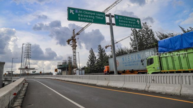 Truk melintas di jalan layang Tol Jakarta - Cikampek yang ditutup di Bekasi, Jawa Barat, Jumat (24/4). [Suara.com/Alfian Winanto]