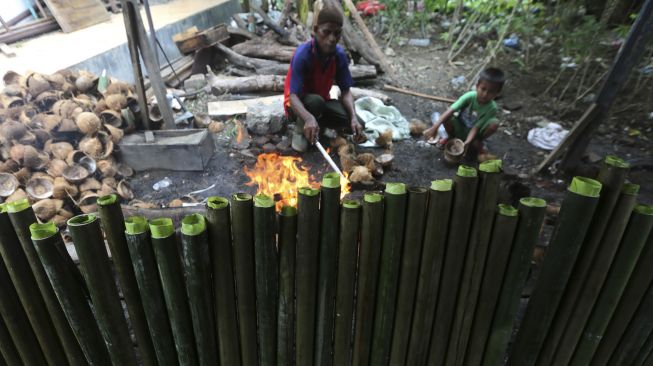 Pengrajin musiman membakar lemang di Desa Suka Ramai, Banda Aceh, Aceh, Sabtu (25/4). [ANTARA FOTO/Irwansyah Putra] 