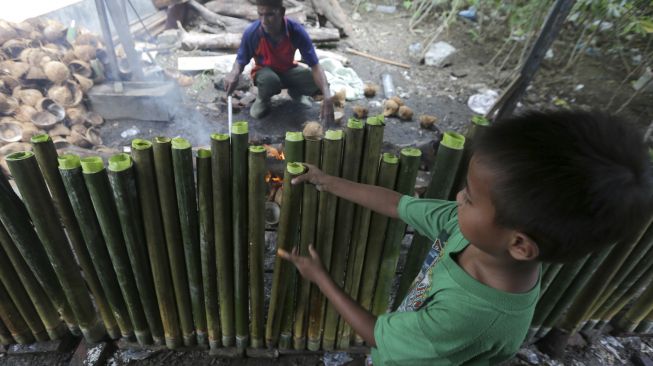 Pengrajin musiman membakar lemang di Desa Suka Ramai, Banda Aceh, Aceh, Sabtu (25/4). [ANTARA FOTO/Irwansyah Putra] 