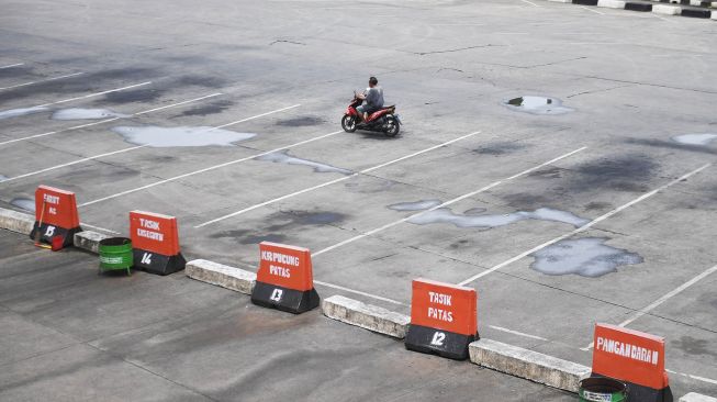 Pengendara motor melintas di Terminal Bus Antar Kota Antar Provinsi (AKAP) Kampung Rambutan yang sepi di Jakarta, Sabtu (25/4). [ANTARA FOTO/Akbar Nugroho Gumay]