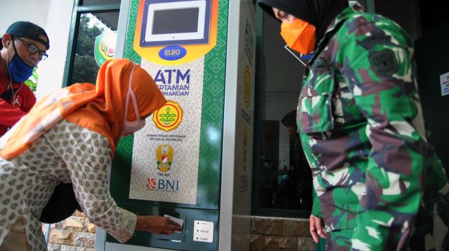 Warga menggunakan ATM Pertanian Sikomandan untuk mendapatkan beras gratis di Kodim 0606/Kota Bogor, Jawa Barat, Sabtu (25/4). [ANTARA FOTO/Arif Firmansyah]