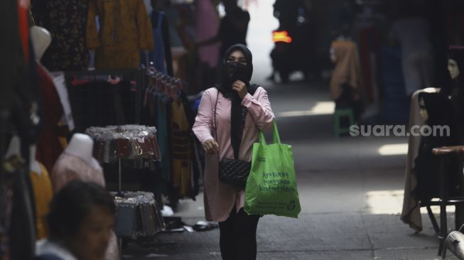 Warga melintas di pasar Tanah Abang yang sepi pengunjung pada hari kedua di bulan suci Ramadhan akibat pandemi virus Corona (COVID-19) di Jakarta, Minggu (26/4). [Suara.com/Angga Budhiyanto]