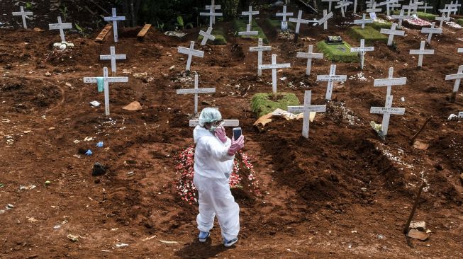 Kerabat dan keluarga jenazah kasus COVID-19 mengunjungi pemakaman di TPU Pondok Ranggon, Jakarta, Minggu (26/4). [ANTARA FOTO/Muhammad Adimaja]