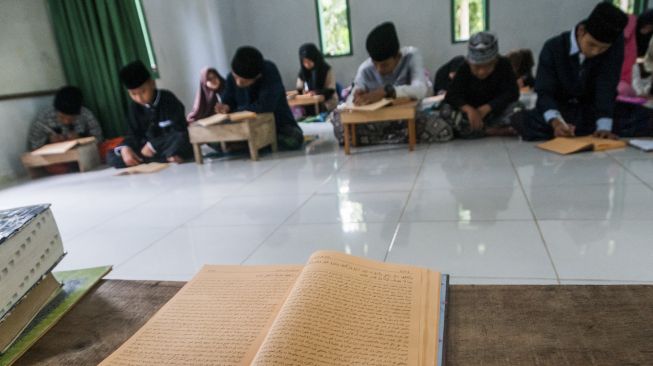 Santri mengikuti kajian kitab kuning di Pondok Pesantren Nurul Ihsan di Kampung Cilewong, Lebak, Banten, Minggu (26/4). [ANTARA FOTO/Muhammad Bagus Khoirunas]