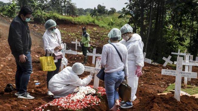 Kerabat dan keluarga jenazah kasus COVID-19 mengunjungi pemakaman di TPU Pondok Ranggon, Jakarta, Minggu (26/4). [ANTARA FOTO/Muhammad Adimaja]