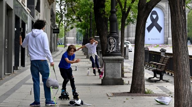 Sejumlah anak bermain sepatu roda ditengah aturan lockdown di Spanyol, Minggu (26/4/2020). [AFP/Gabriel Bouys]