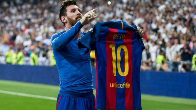 Megabintang Barcelona, Lionel Messi melakukan selebrasi usai mencetak gol dengan memamerkan jersey-nya ke penonton, dalam sebuah pertandingan kontra Real Madrid di Santiago Bernabeu. [AFP]
