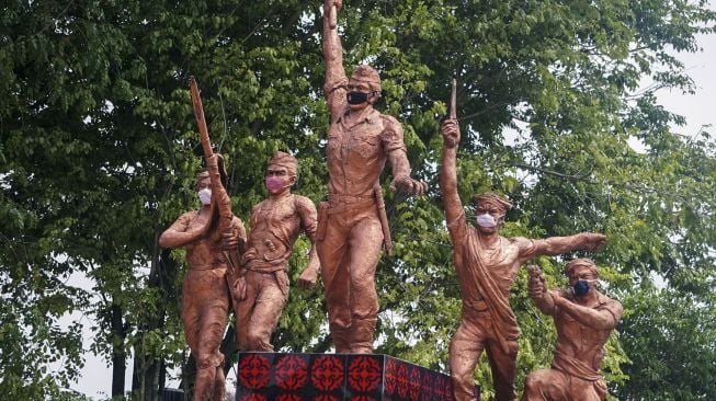 Patung Monumen Djoeang 45 menggunakan masker di Pekalongan, Jawa Tengah, Senin (27/4). [ANTARA FOTO/Harviyan Perdana Putra] 