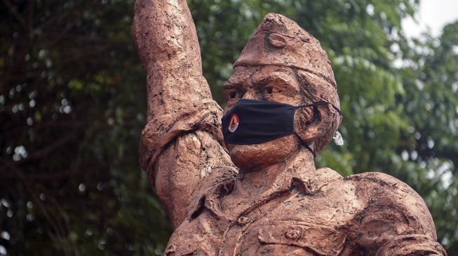 Patung Monumen Djoeang 45 menggunakan masker di Pekalongan, Jawa Tengah, Senin (27/4). [ANTARA FOTO/Harviyan Perdana Putra] 