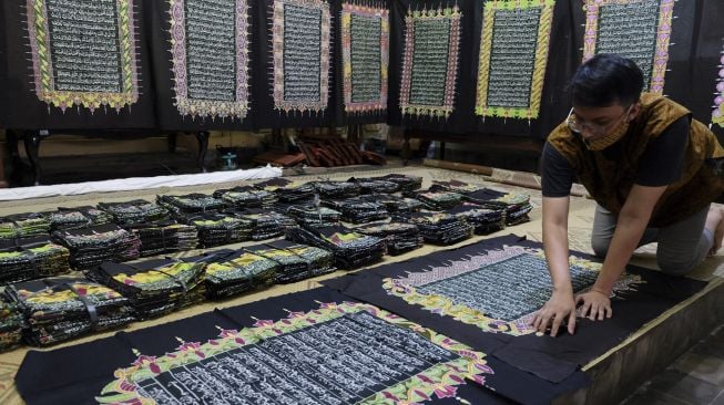 Perajin menunjukkan lembaran batik motif ayat Alquran di Mahkota Batik Laweyan, Solo, Jawa Tengah, Senin (27/4). [ANTARA FOTO/Maulana Surya]