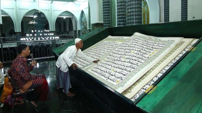 Umat Islam bertadarus membaca Al Quran raksasa di Masjid Baiturrahman, Banyuwangi, Jawa Timur, Senin (27/4). [ANTARA FOTO/Budi Candra Setya]