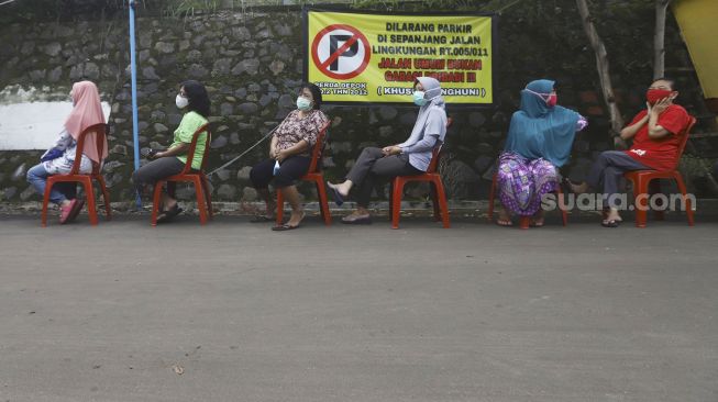 Sejumlah warga mengantre untuk membeli sayur dengan menjaga jarak di Perumahan Taman Anyelir 3, Cilodong, Depok, Jawa Barat, Selasa (28/4).  [Suara.com/Angga Budhiyanto]