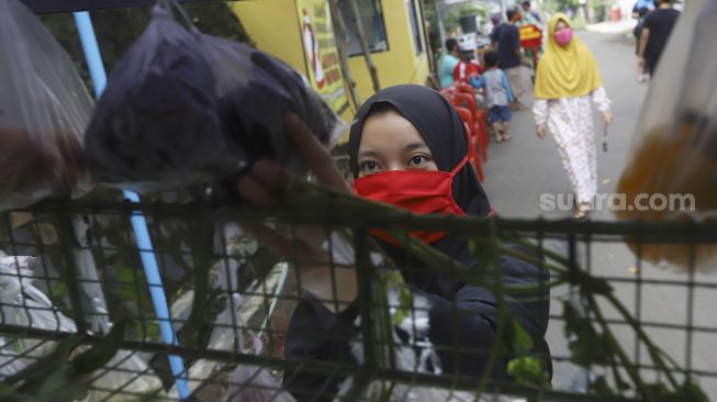 Warga membeli sayur dengan menjaga jarak di Perumahan Taman Anyelir 3, Cilodong, Depok, Jawa Barat, Selasa (28/4). [Suara.com/Angga Budhiyanto]