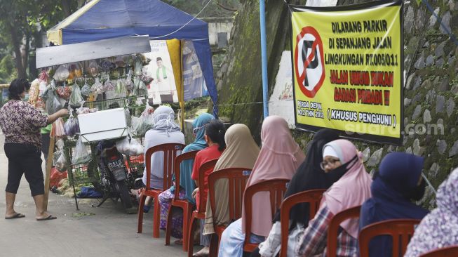 Warga mengantre untuk membeli sayur dengan menjaga jarak di Perumahan Taman Anyelir 3, Cilodong, Depok, Jawa Barat, Selasa (28/4).  [Suara.com/Angga Budhiyanto]