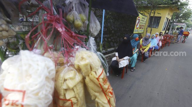 Warga mengantre untuk membeli sayur dengan menjaga jarak di Perumahan Taman Anyelir 3, Cilodong, Depok, Jawa Barat, Selasa (28/4).  [Suara.com/Angga Budhiyanto]
