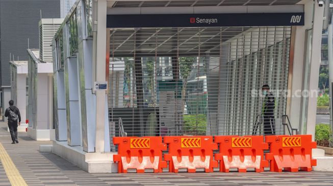 Petugas keamanan berjaga didepan pintu masuk stasiun MRT Senayan, Jakarta Pusat, Rabu (29/4). [Suara.com/Alfian Winanto]