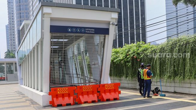 Petugas keamanan berjaga didepan pintu masuk stasiun MRT Senayan, Jakarta Pusat, Rabu (29/4). [Suara.com/Alfian Winanto]