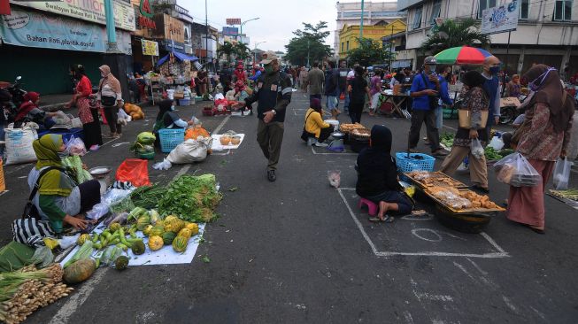 Anggota Satuan Polisi Pamong Praja Kota Salatiga memberi pengumuman waktu pasar pagi akan habis kepada pedagang di Pasar Pagi Salatiga, Jawa Tengah, Rabu (29/4).  [ANTARA FOTO/Aloysius Jarot Nugroho]