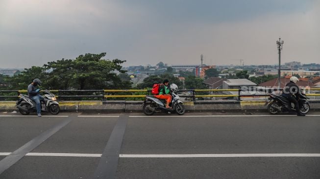 Warga ngabuburit di Flyover Pasar Rebo, Jakarta Timur, Kamis (30/4). [Suara.com/Alfian Winanto]