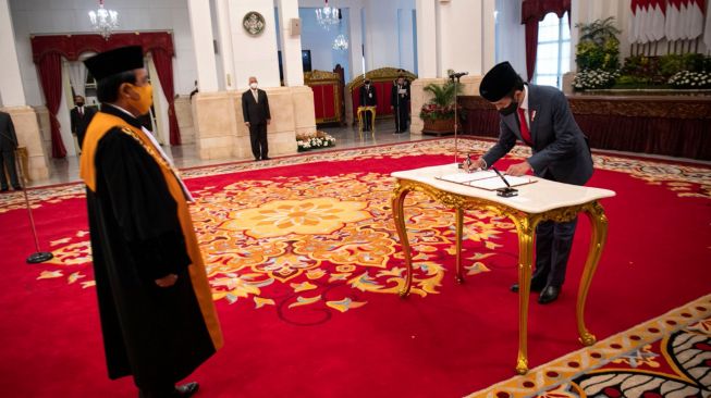 Presiden Joko Widodo (kanan) menandatangani berita acara pelantikan Ketua Mahkamah Agung (MA) terpilih Muhammad Syarifuddin di Istana Negara, Jakarta, Kamis (30/4).  [ANTARA FOTO/Sigid Kurniawan]