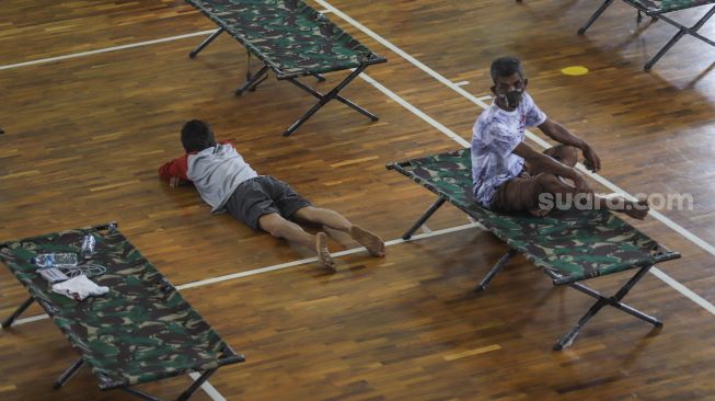 Seorang Tunawisma tiduran di lantai GOR Ciracas, Jakarta Timur, Kamis (30/4). [Suara.com/Alfian Winanto]

