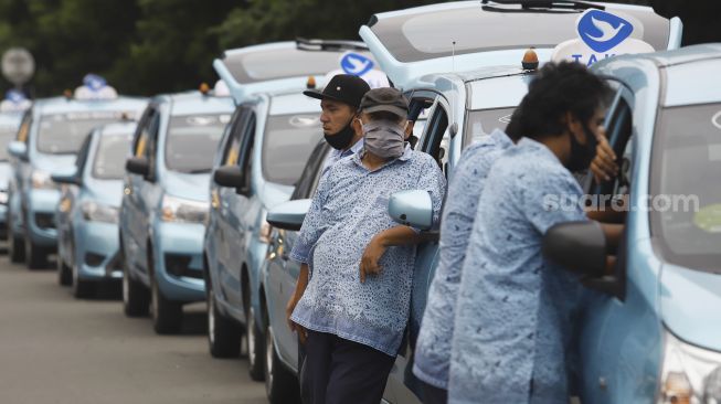 Sejumlah supir taksi menunggu penumpang di Jalan Jenderal Sudirman, Jakarta, Jumat (1/5). [Suara.com/Angga Budhiyanto]