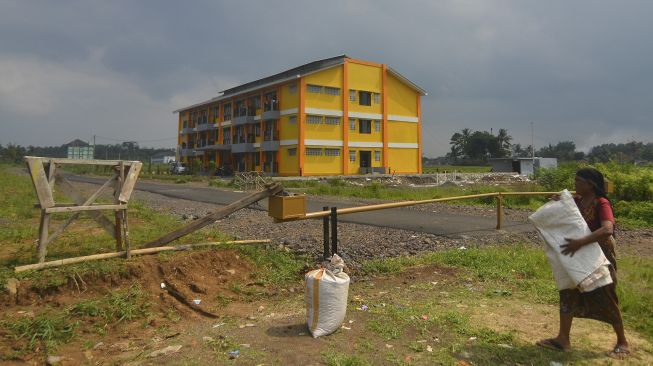 Seorang warga menjemur padi hasil panen di kawasan Rumah Susun Mahasiswa (Rusunawa) Universitas Negeri Siliwangi (Unsil) di Tamansari, Kota Tasikmalaya, Jawa Barat, Jumat (1/5). [ANTARA FOTO/Adeng Bustomi]