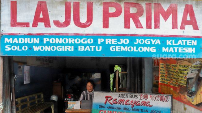 Pegawai agen tiket bus menanti penumpang untuk memesan tiket di Jalan Raya Bogor, Cimanggis, Depok, Jumat (1/5). [Suara.com/Alfian Winanto]