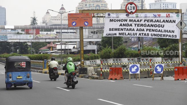 Kendaraan melintas di samping underpass Senen yang ditutup di Jakarta, Jumat (1/5).  [Suara.com/Angga Budhiyanto]