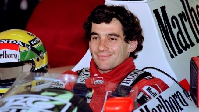 Ayrton Senna, driver F1 asal Brasil tersenyum usai merebut pole position menjelang F1 GP Portugal di Sirkuit Estoril. Balapan berlangsung 23 September, 1989 [AFP/SennaPascal Pavani, Jean-Loup Gautreau].