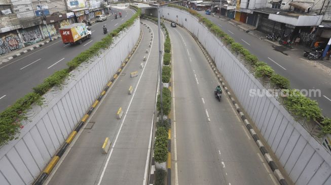 Kendaraan melintas di samping underpass Senen yang ditutup di Jakarta, Jumat (1/5).  [Suara.com/Angga Budhiyanto]