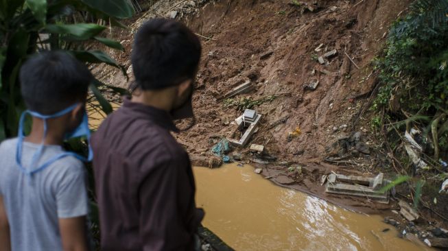 Warga melihat sejumlah makam yang rusak terdampak longsor di TPU Cikutra, Bandung, Jawa Barat, Sabtu (2/5). [ANTARA FOTO/Novrian Arbi]