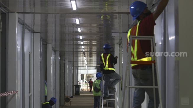 Pekerja menyelesaikan proyek rumah sakit rujukan virus Corona di kompleks Universitas Pertamina, Simprug, Jakarta, Sabtu (2/5). [Suara.com/Angga Budhiyanto]